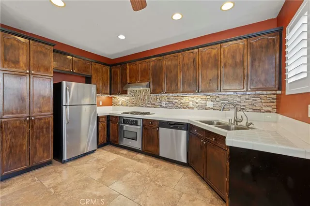 a kitchen with stainless steel appliances granite countertop a refrigerator a sink a stove a microwave and island