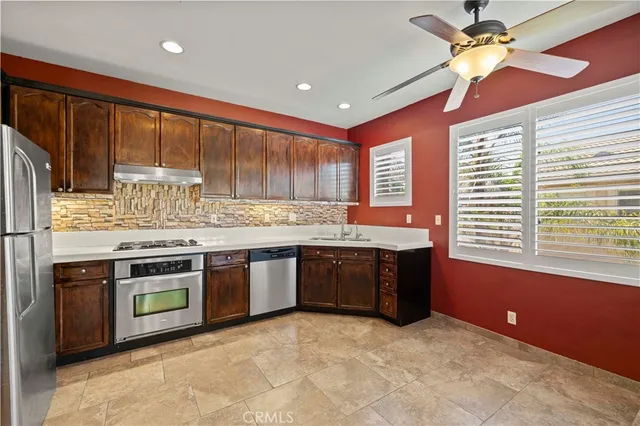 a kitchen with stainless steel appliances granite countertop a stove a sink dishwasher and a refrigerator