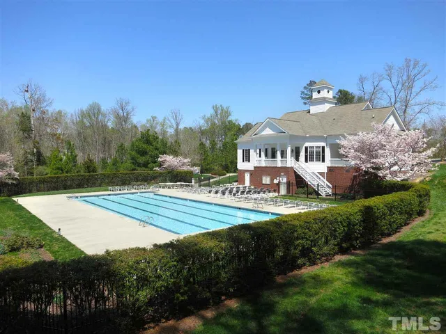 a view of a swimming pool with a yard and trees
