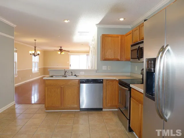 a kitchen with stainless steel appliances granite countertop a refrigerator a sink a stove top oven and a dishwasher
