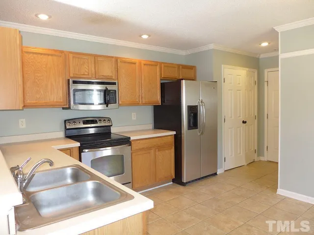 a kitchen with stainless steel appliances granite countertop a refrigerator a stove top oven a sink and dishwasher