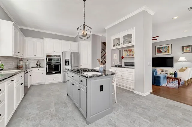 a kitchen with a stove a table and chairs in it