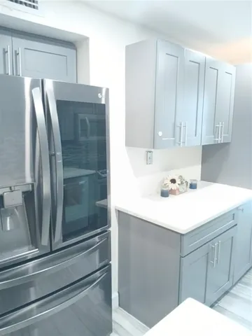 a kitchen with a refrigerator sink and cabinets