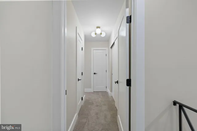 a view of a hallway with wooden floor and closet
