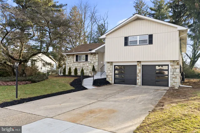 a view of a house with a yard and large tree