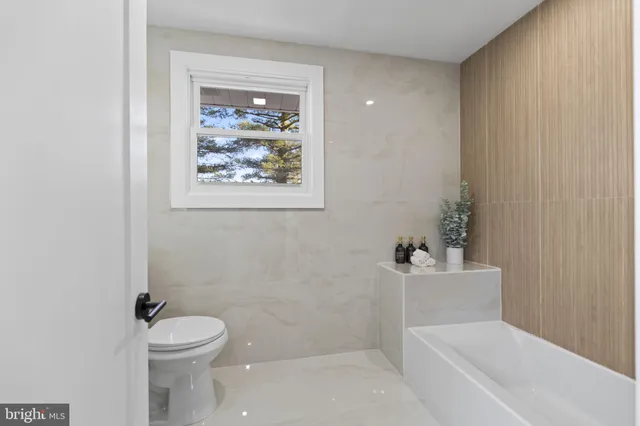 a white toilet sitting next to a bath tub