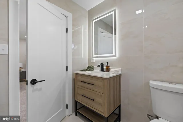 a bathroom with a sink a toilet and a mirror