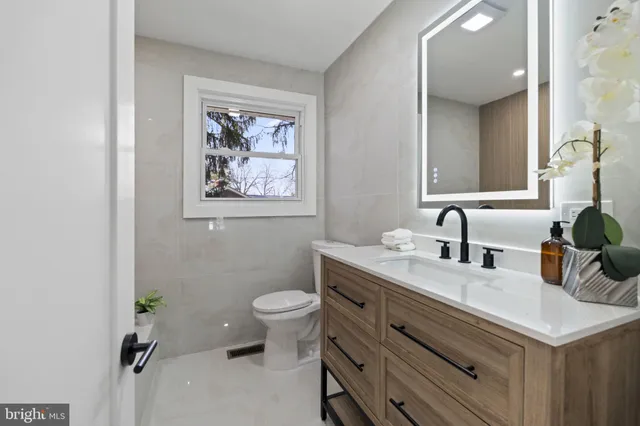 a bathroom with a toilet sink and mirror