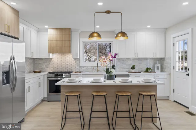 a kitchen with stainless steel appliances granite countertop a stove a sink and a refrigerator