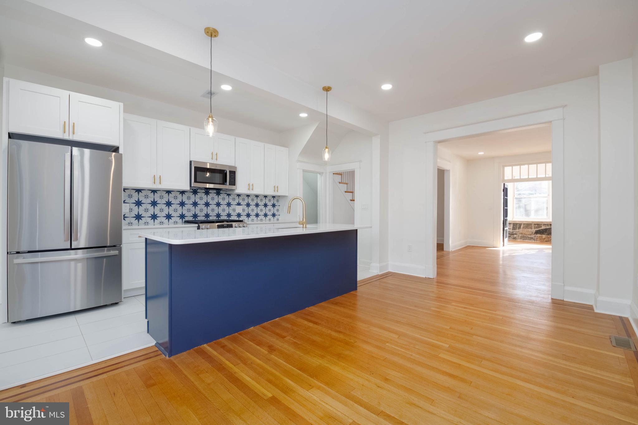 1202 West 42nd Street Baltimore, MD 21211 - Photo 12 of 47 a kitchen with stainless steel appliances a refrigerator and a wooden floor