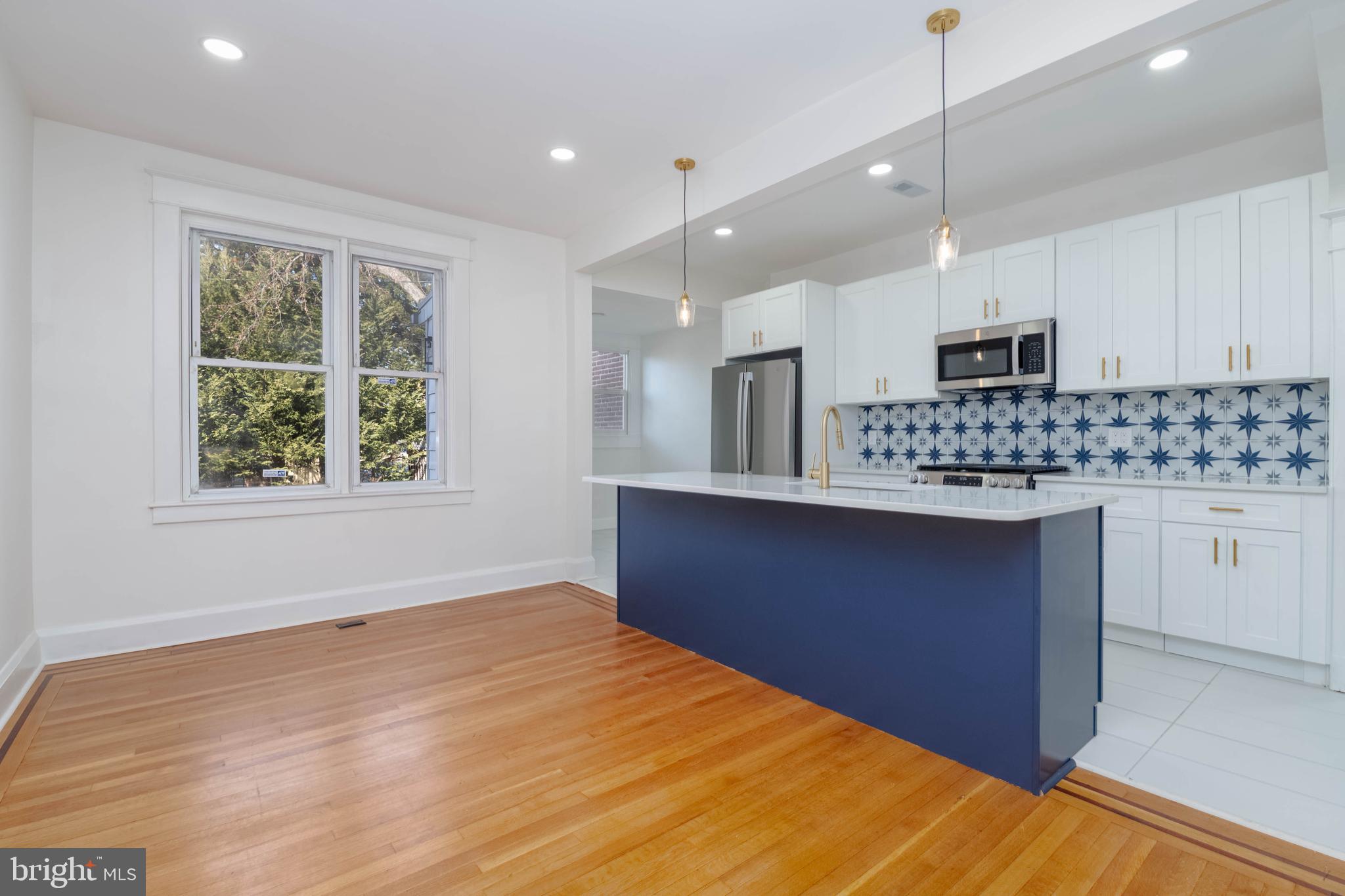 1202 West 42nd Street Baltimore, MD 21211 - Photo 13 of 47 a kitchen with stainless steel appliances granite countertop a stove a sink and a microwave
