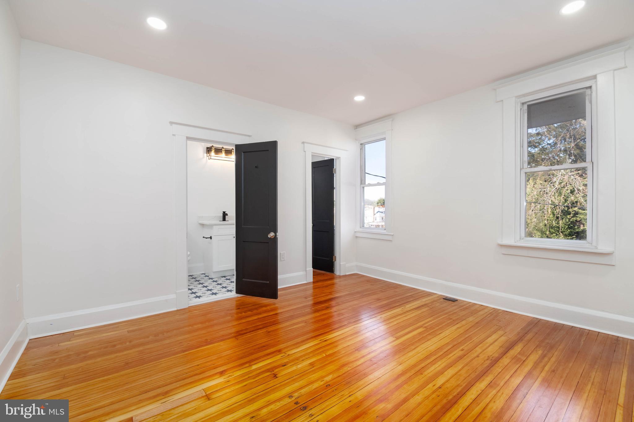 1202 West 42nd Street Baltimore, MD 21211 - Photo 16 of 47 a view of an empty room with wooden floor and a window