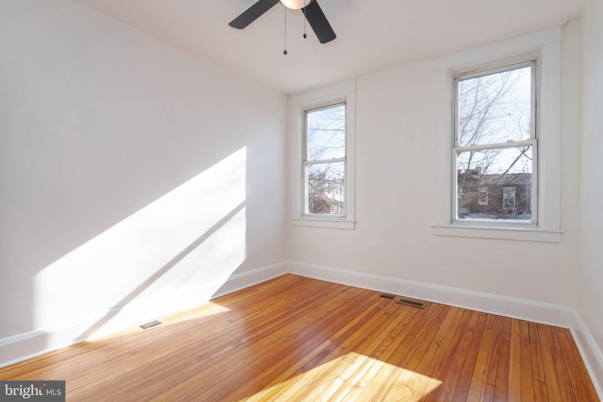 1202 West 42nd Street Baltimore, MD 21211 - Photo 23 of 47 a view of empty room with wooden floor and fan