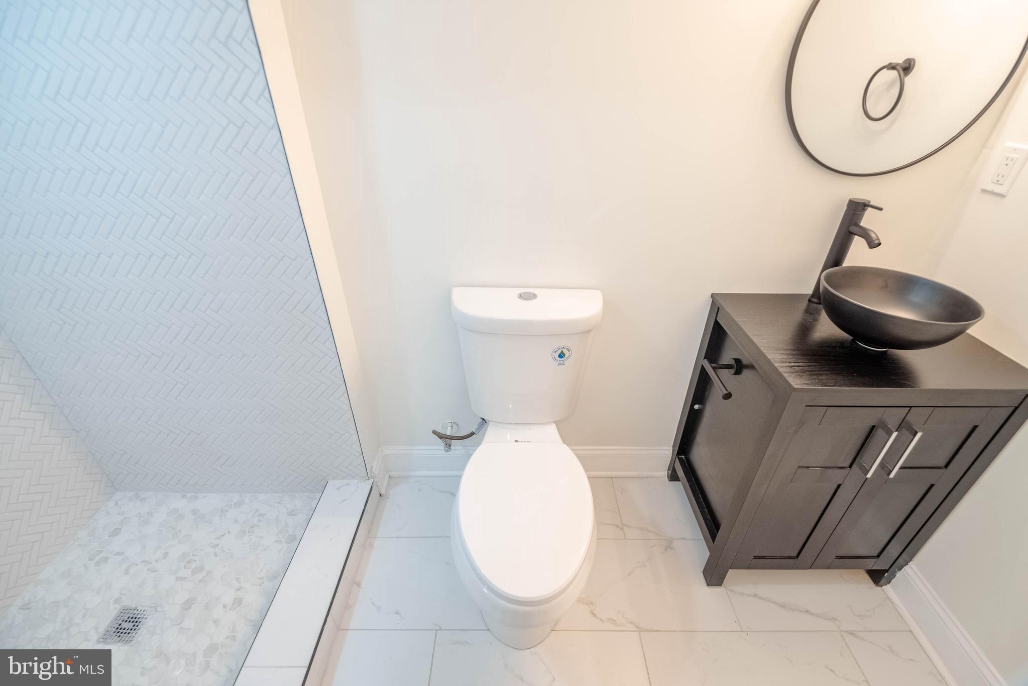 1202 West 42nd Street Baltimore, MD 21211 - Photo 37 of 47 a bathroom with a sink and mirror