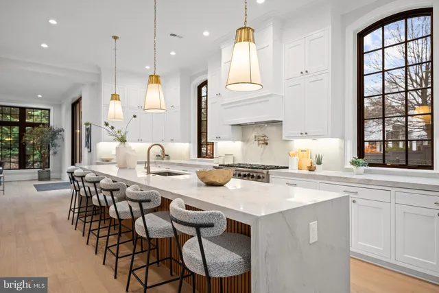 a kitchen with stainless steel appliances granite countertop a table chairs sink and cabinets