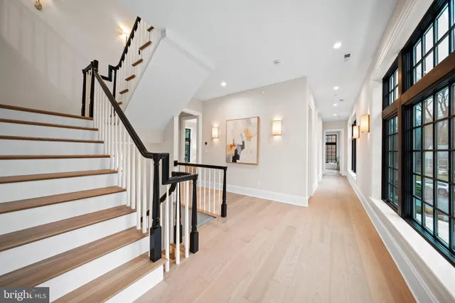 a view of a hallway with wooden floor and stairs