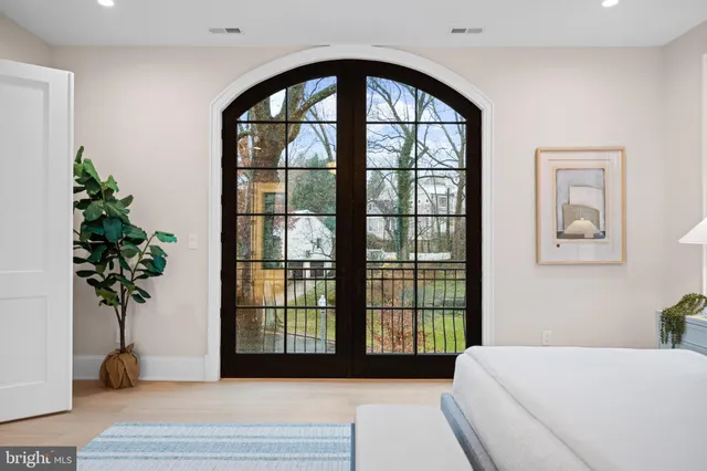 a living room with a large window and a potted plant