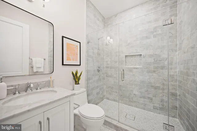 a bathroom with a granite countertop sink toilet and shower