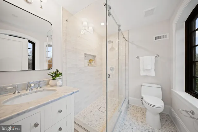 a bathroom with a granite countertop sink toilet and shower