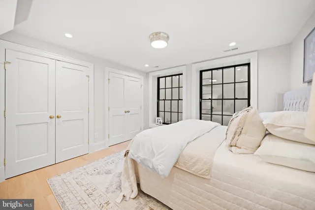 a bedroom with a large bed and a wooden floor