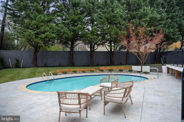 a view of swimming pool with table and chairs under an umbrella