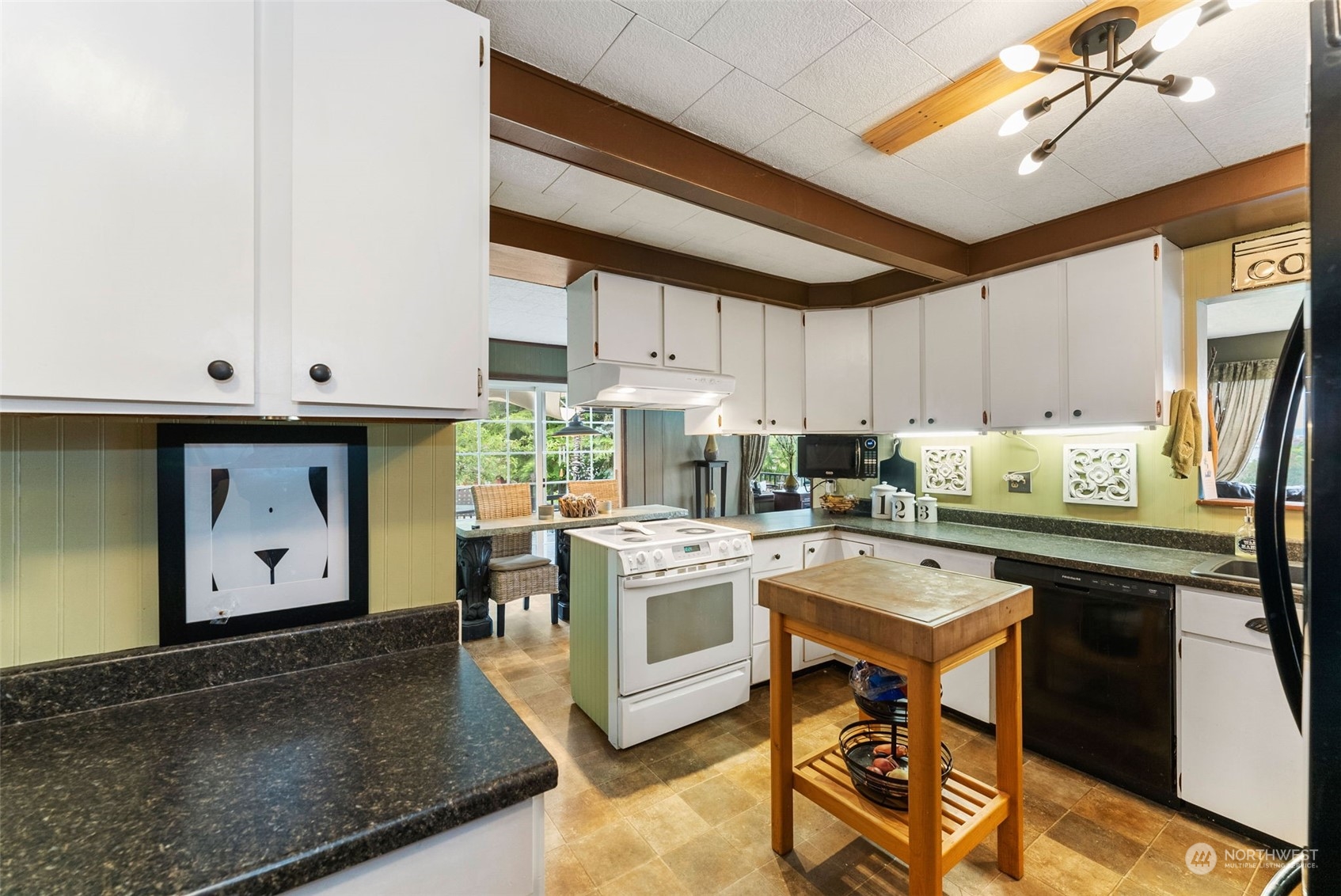7911 East Maple Street Port Orchard, WA 98366 - Photo 17 of 39 a kitchen with a table chairs stove and cabinets