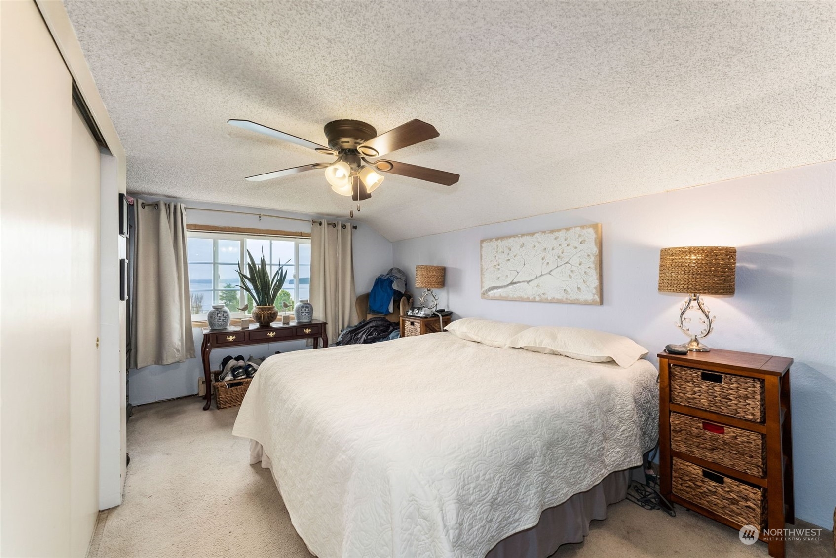 7911 East Maple Street Port Orchard, WA 98366 - Photo 29 of 39 a bedroom with a bed and a chandelier