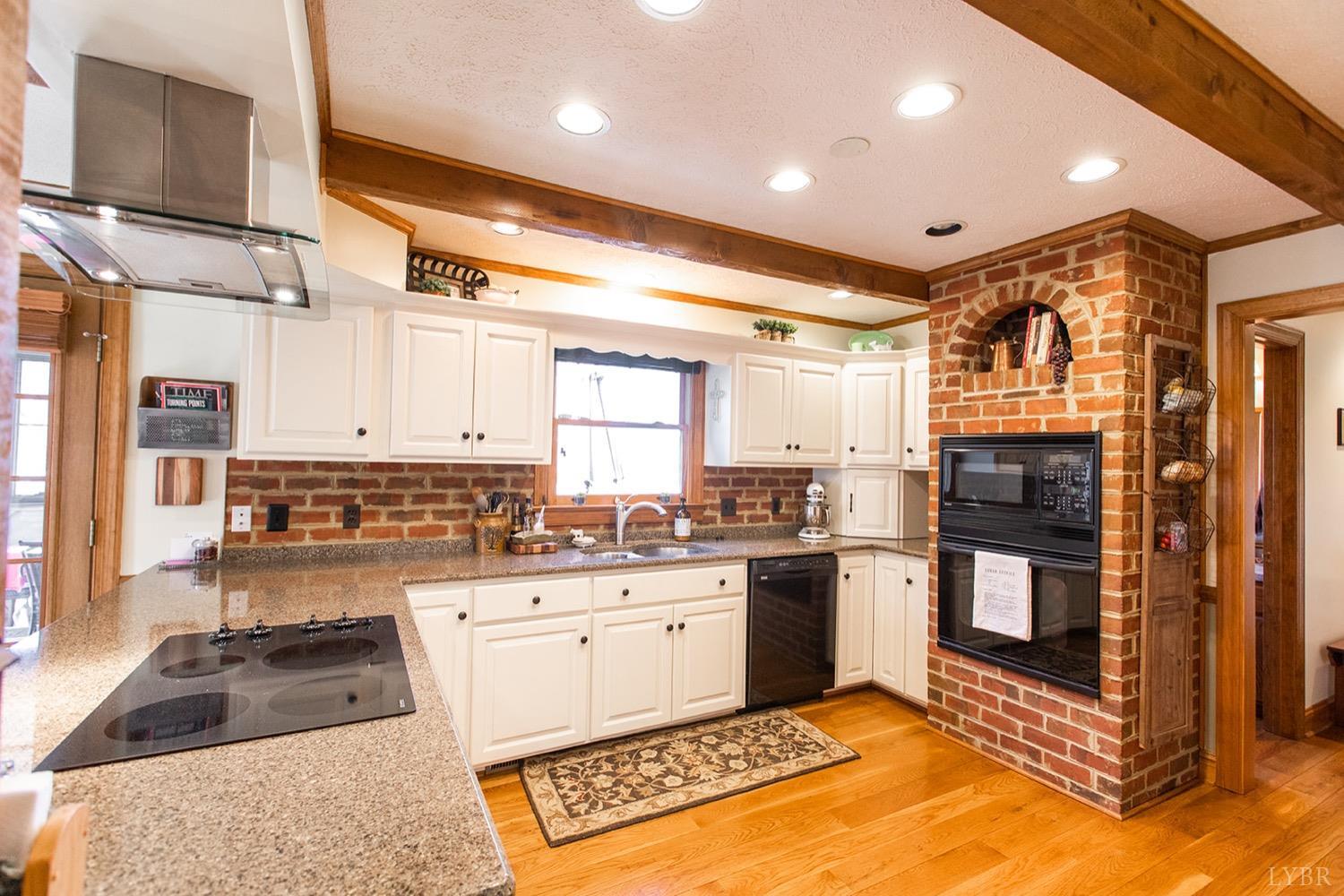 2096 Austin Mill Road Evington, VA 24550 - Photo 15 of 44 a kitchen with stainless steel appliances granite countertop a stove top oven a sink a counter space and cabinets