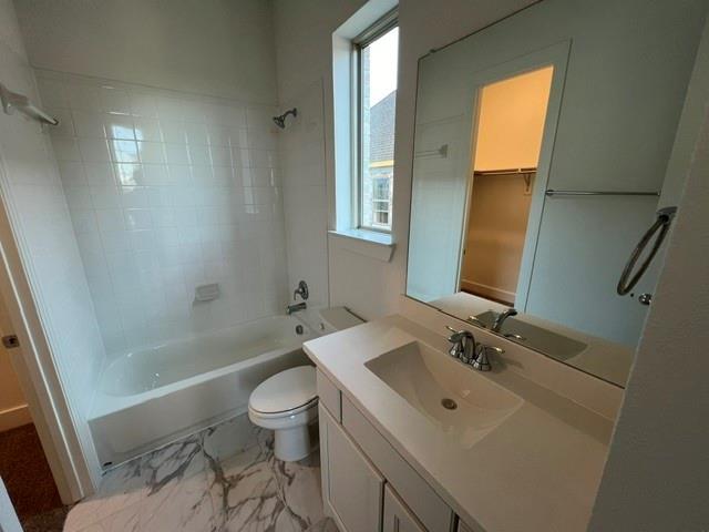 1407 Cartona Road Fate, TX 75087 - Photo 11 of 21 Bathroom featuring a white tile tub surround, a single window, a toilet, a vanity with an integrated sink, and a large wall mirror