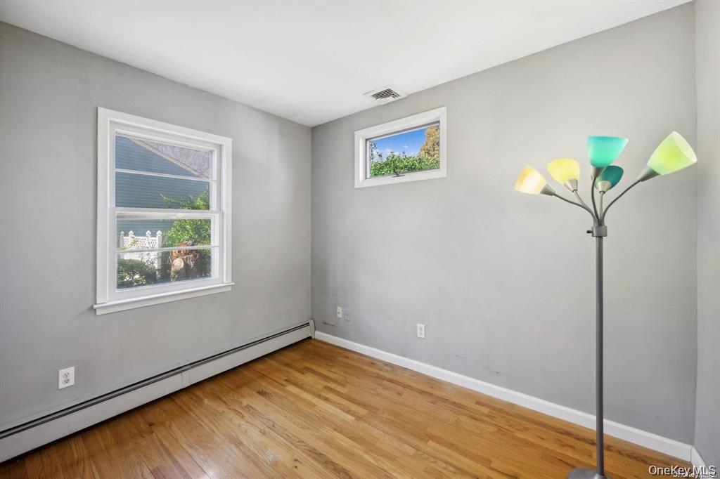 301 Laurel Road Northport, NY 11768 - Photo 6 of 12 Spare room with a baseboard heating unit and light wood-type flooring