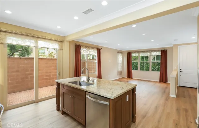 a view of kitchen with granite countertop sink refrigerator and wooden floor