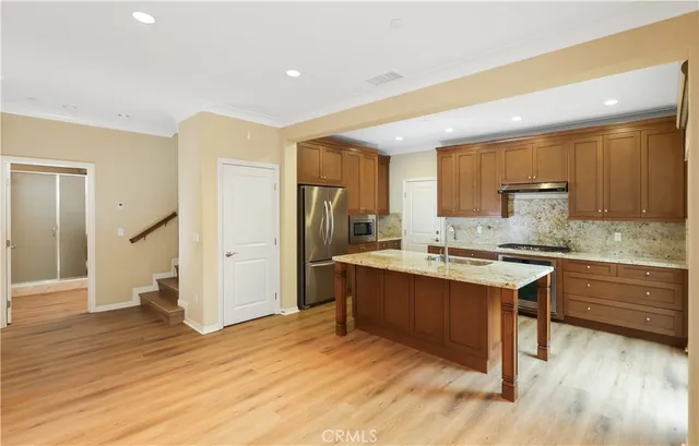 a kitchen with granite countertop a sink cabinets and wooden floor