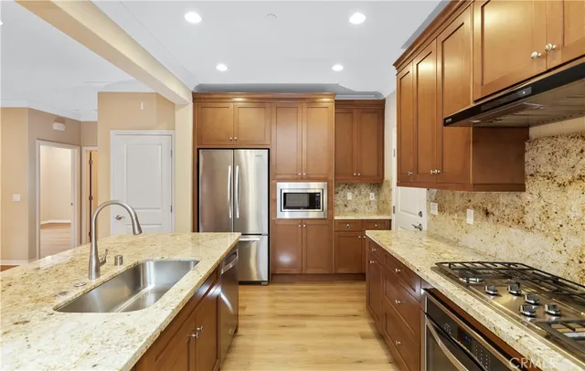 a kitchen with granite countertop a sink stainless steel appliances and cabinets