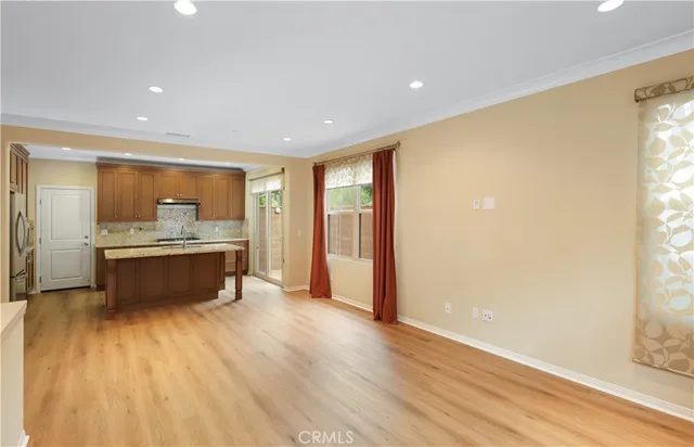 a large kitchen with a large counter top a sink stainless steel appliances and cabinets