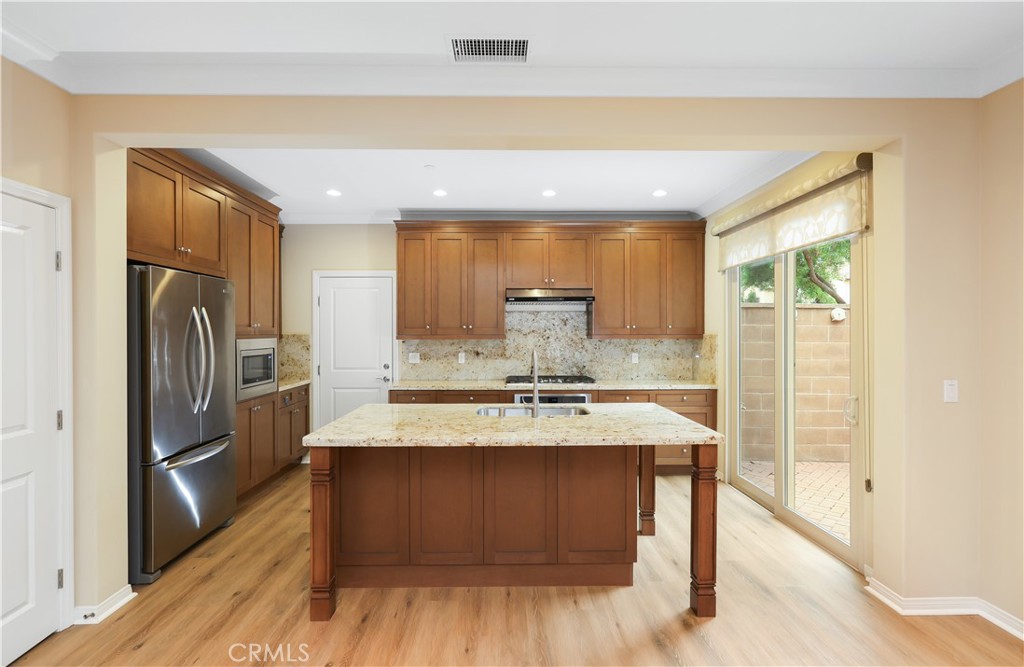 220 Kempton Irvine, CA 92620 - Photo 10 of 42 a kitchen with a refrigerator a sink and cabinets