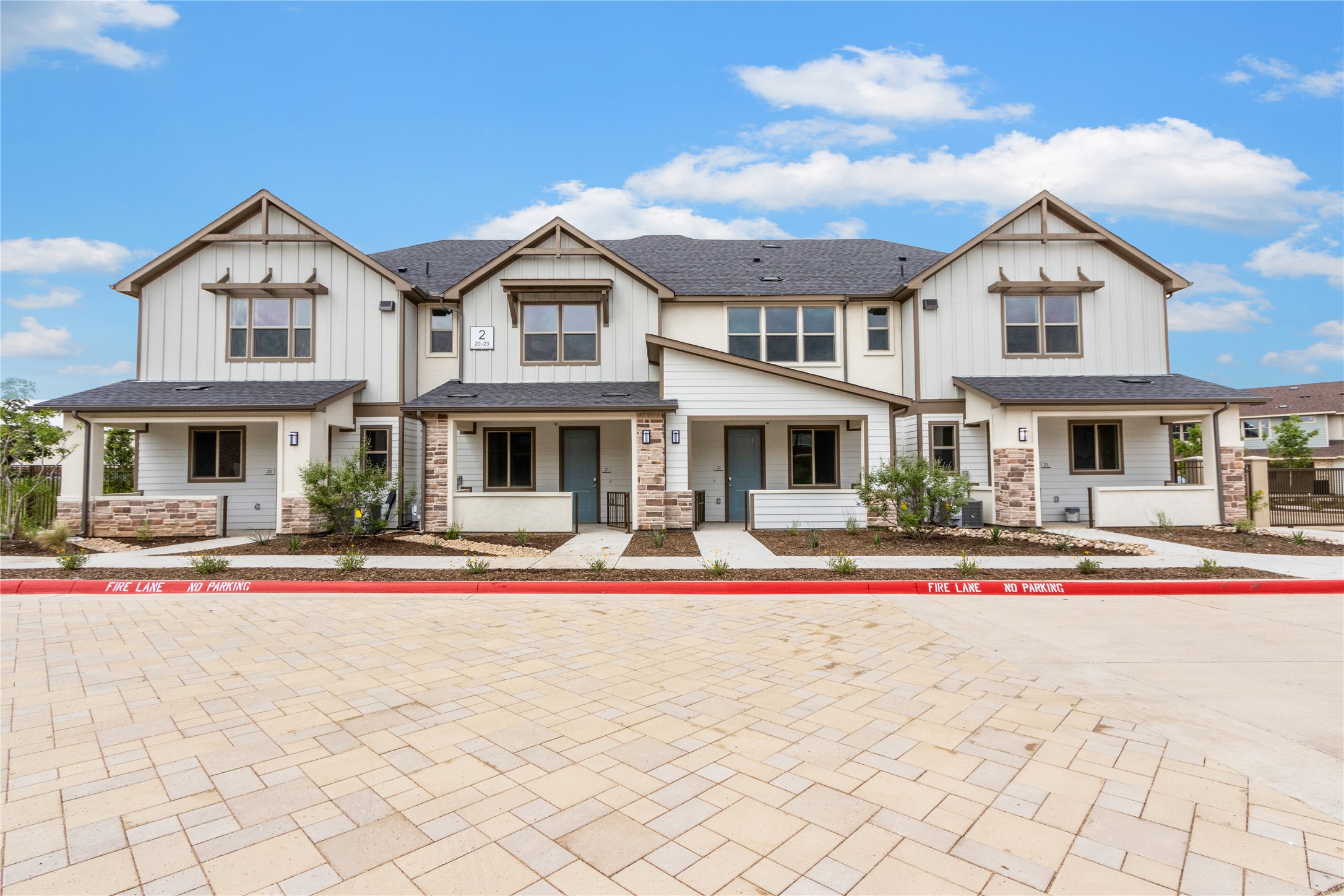 a front view of a residential houses with yard and road