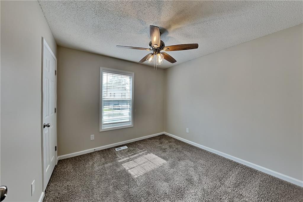 108 Ivy Trace Lane Dallas, GA 30157 - Photo 13 of 23 an empty room with a chandelier fan and windows