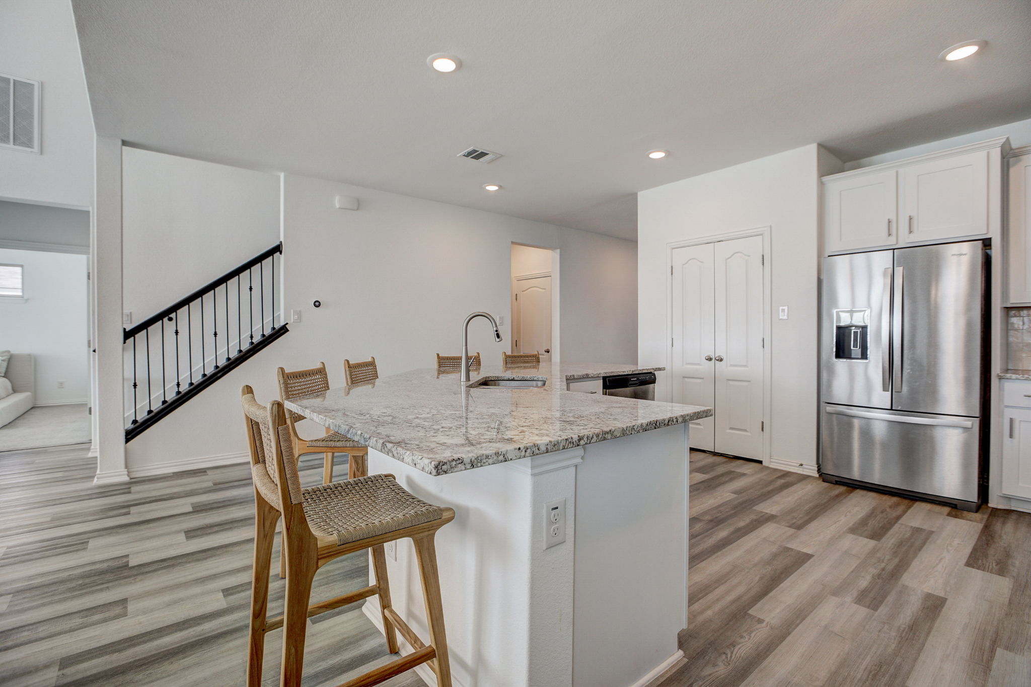 308 Monteforte Road Hutto, TX 78634 - Photo 9 of 32 a kitchen with stainless steel appliances granite countertop a kitchen island a stove a refrigerator and white cabinets with wooden floor
