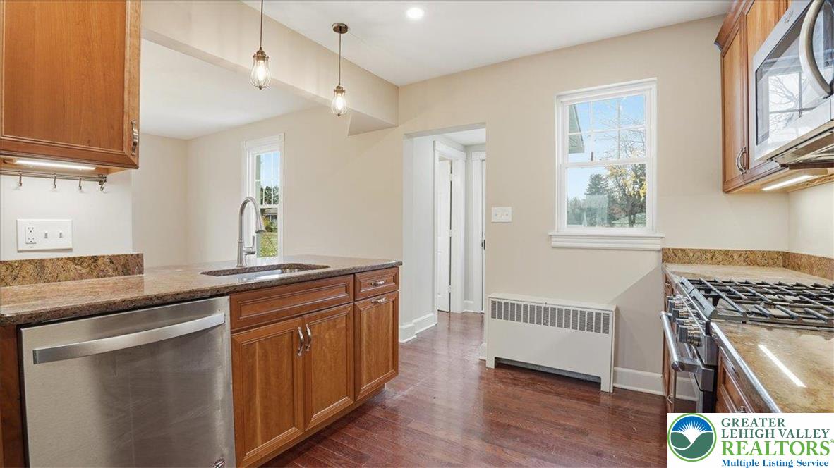 4441 Newburg Road Nazareth, PA 18064 - Photo 21 of 65 a kitchen with stainless steel appliances granite countertop a sink and wooden floor