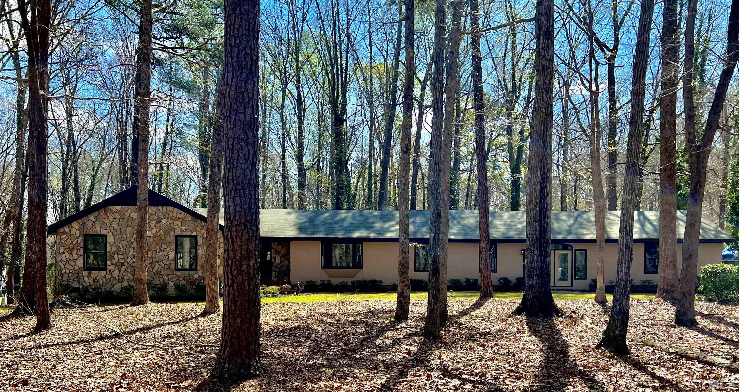 a view of a house with backyard and trees