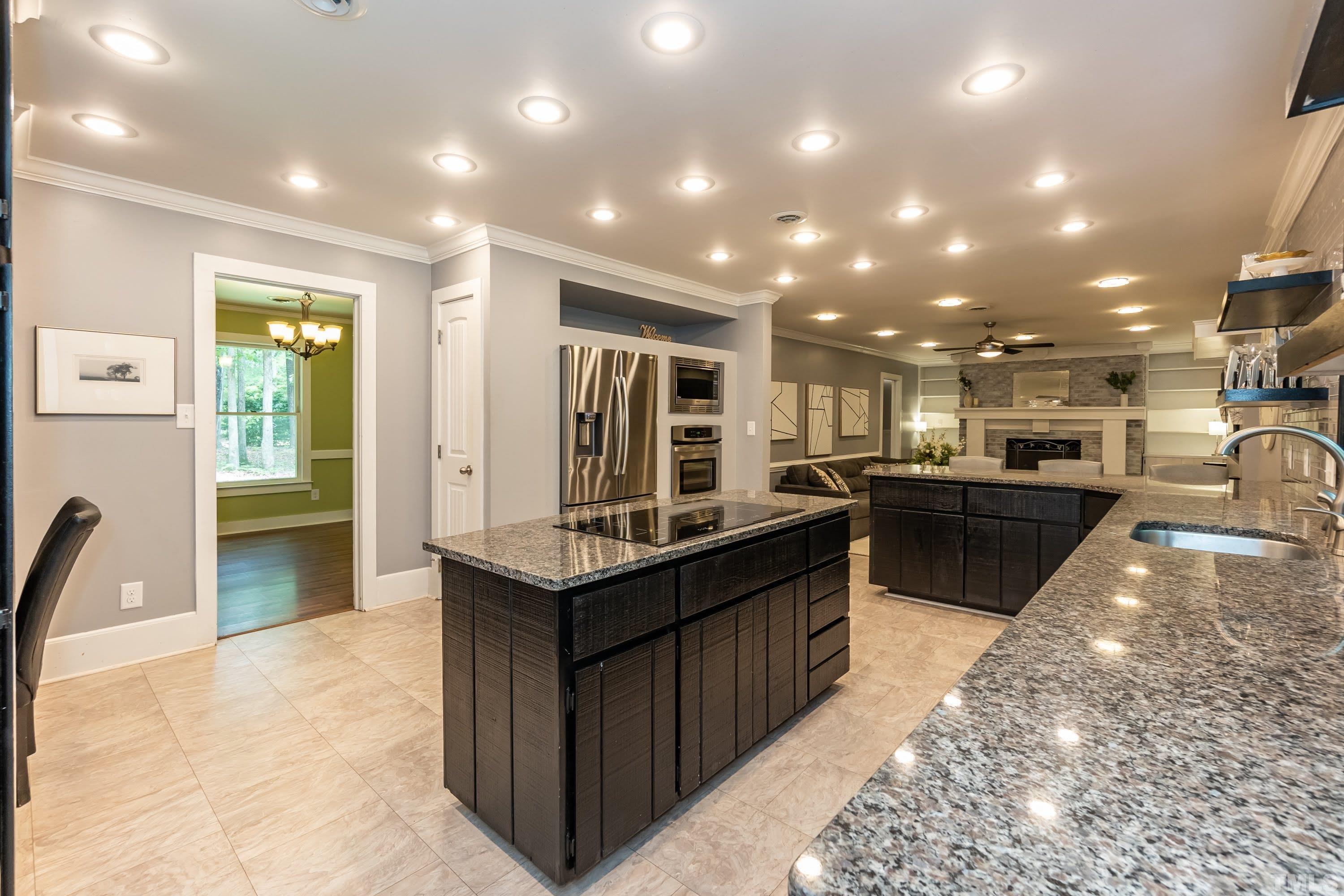 5601 Dutchman Drive Raleigh, NC 27606 - Photo 12 of 43 a kitchen with stainless steel appliances kitchen island granite countertop a sink and cabinets