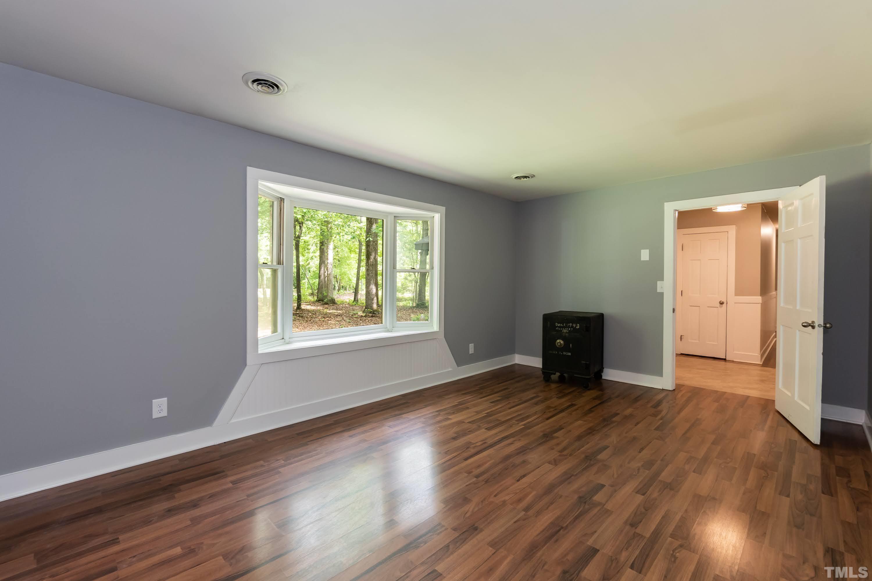 5601 Dutchman Drive Raleigh, NC 27606 - Photo 19 of 43 an empty room with wooden floor and windows