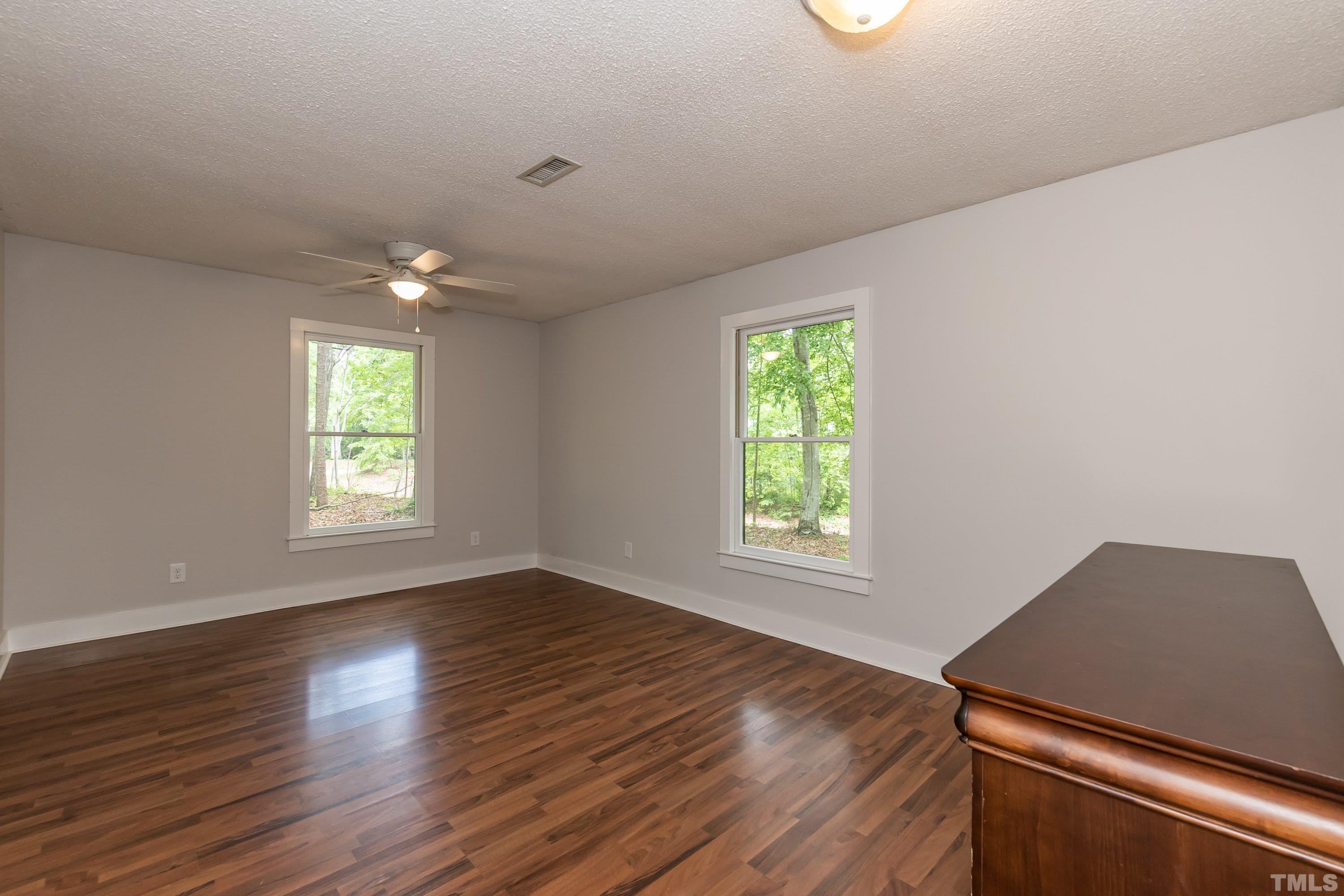 5601 Dutchman Drive Raleigh, NC 27606 - Photo 21 of 43 an empty room with wooden floor and windows