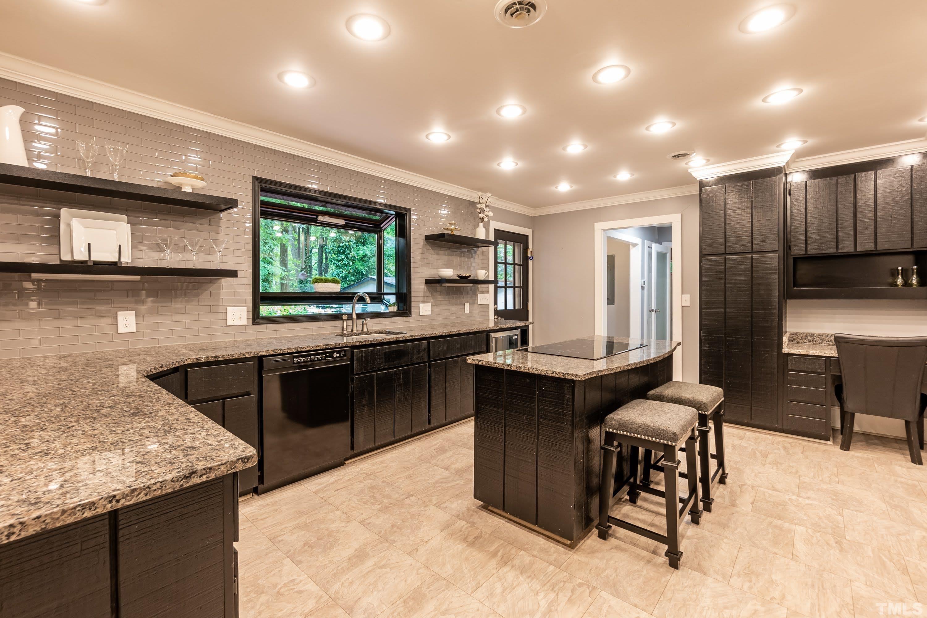 5601 Dutchman Drive Raleigh, NC 27606 - Photo 10 of 43 a kitchen with stainless steel appliances kitchen island granite countertop a table chairs sink and cabinets