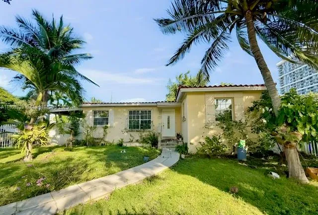 a view of a house with a yard and potted plants