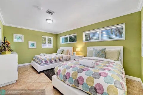 a bedroom with two beds and painting on the wall