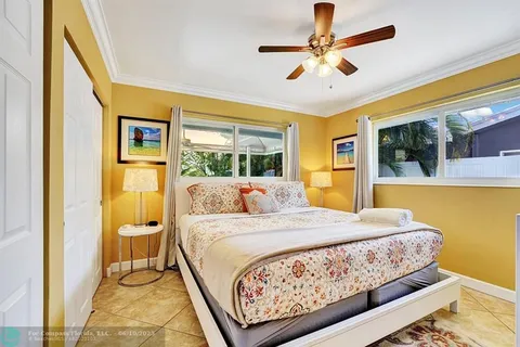 a bedroom with a large bed and ceiling fan
