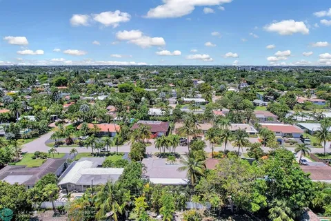an aerial view of residential houses with outdoor space and trees