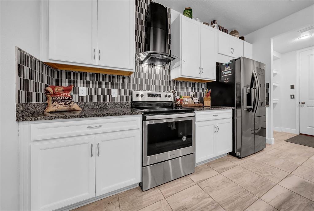 4007 Palm Key Avenue Oldsmar, FL 34677 - Photo 7 of 30 a kitchen with stainless steel appliances a stove and white cabinets