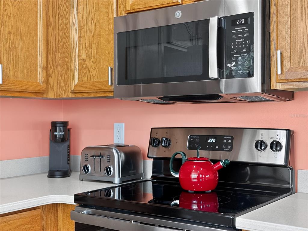 920 Spring Park Street, Unit 303 Celebration, FL 34747 - Photo 13 of 40 a kitchen with granite countertop a stove and cabinets